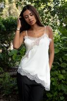 Woman wearing TIC TOC TA31968 SELINNE satin lace contrast V-neck cami top featuring smooth satin fabric, a flattering V neckline with scalloped lace trim, thin adjustable shoulder straps, and an asymmetrical lace-trim hem for a soft feminine date-night look.