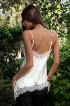 Woman wearing TIC TOC TA31968 SELINNE satin lace contrast V-neck cami top featuring smooth satin fabric, a flattering V neckline with scalloped lace trim, thin adjustable shoulder straps, and an asymmetrical lace-trim hem for a soft feminine date-night look.