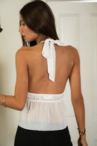 Woman wearing TIC TOC TA32010 DOTTY open back deep V-neck polka dot halter top featuring a lightweight micro polka dot chiffon fabric, deep V neckline, self-tie halter neck, dual elastic back bands, and a ruffled sheer chiffon hem for a flirty romantic summer look.