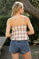 Woman wearing TIC TOC TA32071 POPPY plaid lace bow sleeveless top featuring an allover plaid check pattern, lace-trim V-neckline with matching straps, front bow tie detail at the bust, cropped length with a slight flare hem, and an elastic back panel for a feminine coquette-inspired summer look.