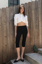 Woman wearing MAIZY eyelet trim cropped three quarter sleeve poplin blouse featuring lightweight cotton poplin fabric, romantic high ruffle neckline, delicate eyelet lace trim, open front cropped silhouette, voluminous puff sleeves, elastic ruffle cuffs, and elasticized hem for feminine styling.