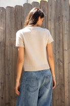 Woman wearing ADELE soft knit button short sleeve cardigan featuring plush sweater knit fabric, cozy comfortable feel, classic crew neckline, button front closure, short sleeves with ribbed cuffs and hem, and a relaxed yet flattering everyday fit for easy layering.