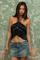 Woman wearing TIC TOC TC31634 VIXARA cropped fringe halter top featuring allover fringe tassel detailing, a flattering V-cut bust line with mesh lining, faux button detail at the halter neck, and a cropped silhouette, styled for a festival-ready western concert look.