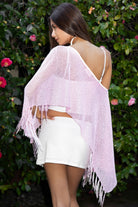 Woman wearing TIC TOC TC31650-SOLENA SOLENA crystal sequin crochet poncho featuring lightweight open crochet knit fabric, allover crystal sequin embellishments, a wide off-shoulder neckline, relaxed draped poncho silhouette, cropped asymmetrical hem, and thin tassel fringe detail, styled over a fitted inner layer for a western festival and vacation-ready look.