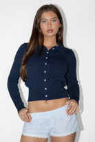 Woman wearing TIC TOC TC31963-RORYN RORYN long sleeve button-up cardigan featuring a slim fit silhouette, classic cable knit texture, collared neckline, ribbed cuffs and waistband, and a soft lightweight sweater knit feel, styled with denim for an easy everyday layered look.