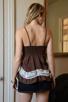 Woman wearing TIC TOC TC31970 EMMARA lace contrast polka dot babydoll cami top featuring soft peachskin fabric with a micro polka dot print, delicate lace contrast panels at the bust and hem, adjustable thin straps, a smocked back panel, and a softly draped babydoll silhouette for a romantic vintage-inspired look.