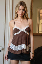 Woman wearing TIC TOC TC31970 EMMARA lace contrast polka dot babydoll cami top featuring soft peachskin fabric with a micro polka dot print, delicate lace contrast panels at the bust and hem, adjustable thin straps, a smocked back panel, and a softly draped babydoll silhouette for a romantic vintage-inspired look.