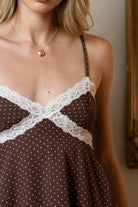 Woman wearing TIC TOC TC31970 EMMARA lace contrast polka dot babydoll cami top featuring soft peachskin fabric with a micro polka dot print, delicate lace contrast panels at the bust and hem, adjustable thin straps, a smocked back panel, and a softly draped babydoll silhouette for a romantic vintage-inspired look.