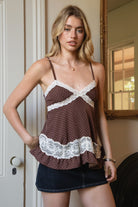 Woman wearing TIC TOC TC31970 EMMARA lace contrast polka dot babydoll cami top featuring soft peachskin fabric with a micro polka dot print, delicate lace contrast panels at the bust and hem, adjustable thin straps, a smocked back panel, and a softly draped babydoll silhouette for a romantic vintage-inspired look.