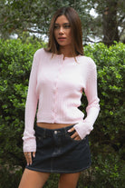 Woman wearing TIC TOC TC32069 KRISTY cable knit basic long sleeve cardigan top featuring a soft lightweight cotton cable knit texture, round neckline, full front button closure, slim fit silhouette, and semi-cropped length for a polished preppy everyday look.