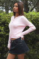 Woman wearing TIC TOC TC32069 KRISTY cable knit basic long sleeve cardigan top featuring a soft lightweight cotton cable knit texture, round neckline, full front button closure, slim fit silhouette, and semi-cropped length for a polished preppy everyday look.