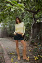 Woman wearing TIC TOC TC32069 KRISTY cable knit basic long sleeve cardigan top featuring a soft lightweight cotton cable knit texture, round neckline, full front button closure, slim fit silhouette, and semi-cropped length for a polished preppy everyday look.