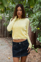 Woman wearing TIC TOC TC32069 KRISTY cable knit basic long sleeve cardigan top featuring a soft lightweight cotton cable knit texture, round neckline, full front button closure, slim fit silhouette, and semi-cropped length for a polished preppy everyday look.