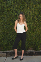 Woman wearing LOTTIE polka dot print lace contrast jersey tank featuring a delicate polka dot print, V-neckline with self-tie bow detail, lace trim along the neckline and under bust, adjustable thin straps, and a soft stretch jersey body-skimming silhouette.