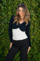 Woman wearing ARDEN V-neck long sleeve cable knit bolero cardigan featuring a classic cable knit design, cropped bolero silhouette, three-button front closure, ribbed cuffs and hem, and soft cotton knit fabric for comfortable everyday layering.