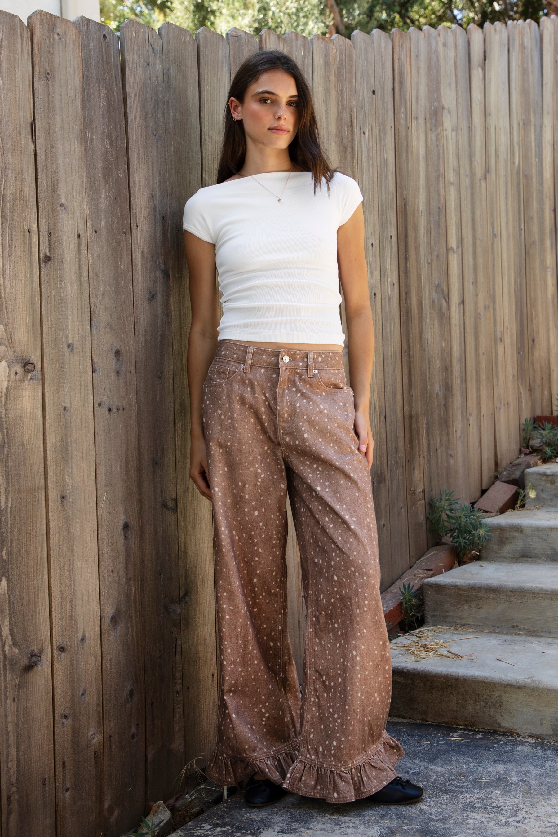 Woman wearing AURA boat neck short sleeve rib jersey top featuring soft rib jersey fabric, wide boat neckline, convertible off shoulder styling, fitted silhouette, comfortable stretch, short cap sleeves, and smooth lightweight ribbed texture for everyday looks and elevated basics.
