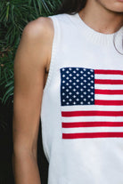 Woman wearing LIBBY American flag sweater knit tank featuring soft breathable 100% cotton sweater knit fabric, clean fitted silhouette, classic crew neckline, sleeveless design, American flag knit graphic across the front, ribbed trim along the neckline and armholes, and ribbed hem for a structured finish.