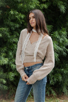 Woman wearing ELIA embroidered lace thin scarf featuring delicate sheer crochet lace fabric, intricate diamond pattern embroidery, soft textured dotted embroidery details, narrow skinny scarf silhouette, scalloped lace trim along both edges, and long tapered ends for a romantic vintage inspired look.