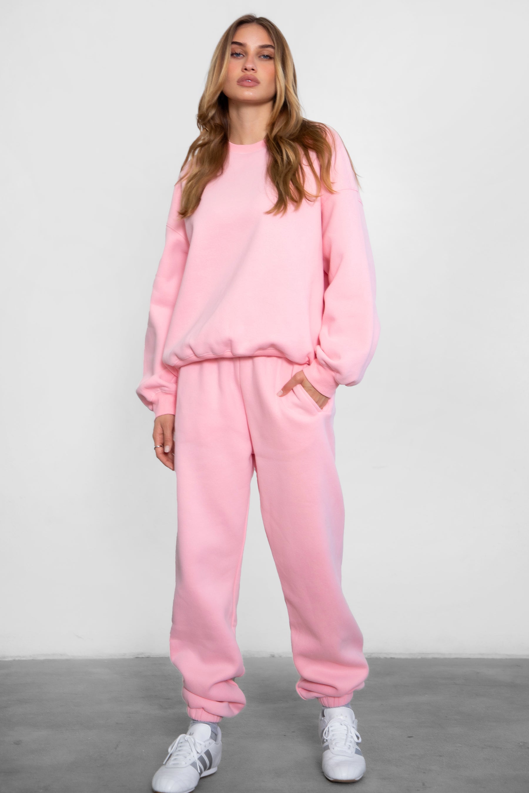 Person wearing a pink tracksuit on a plain background