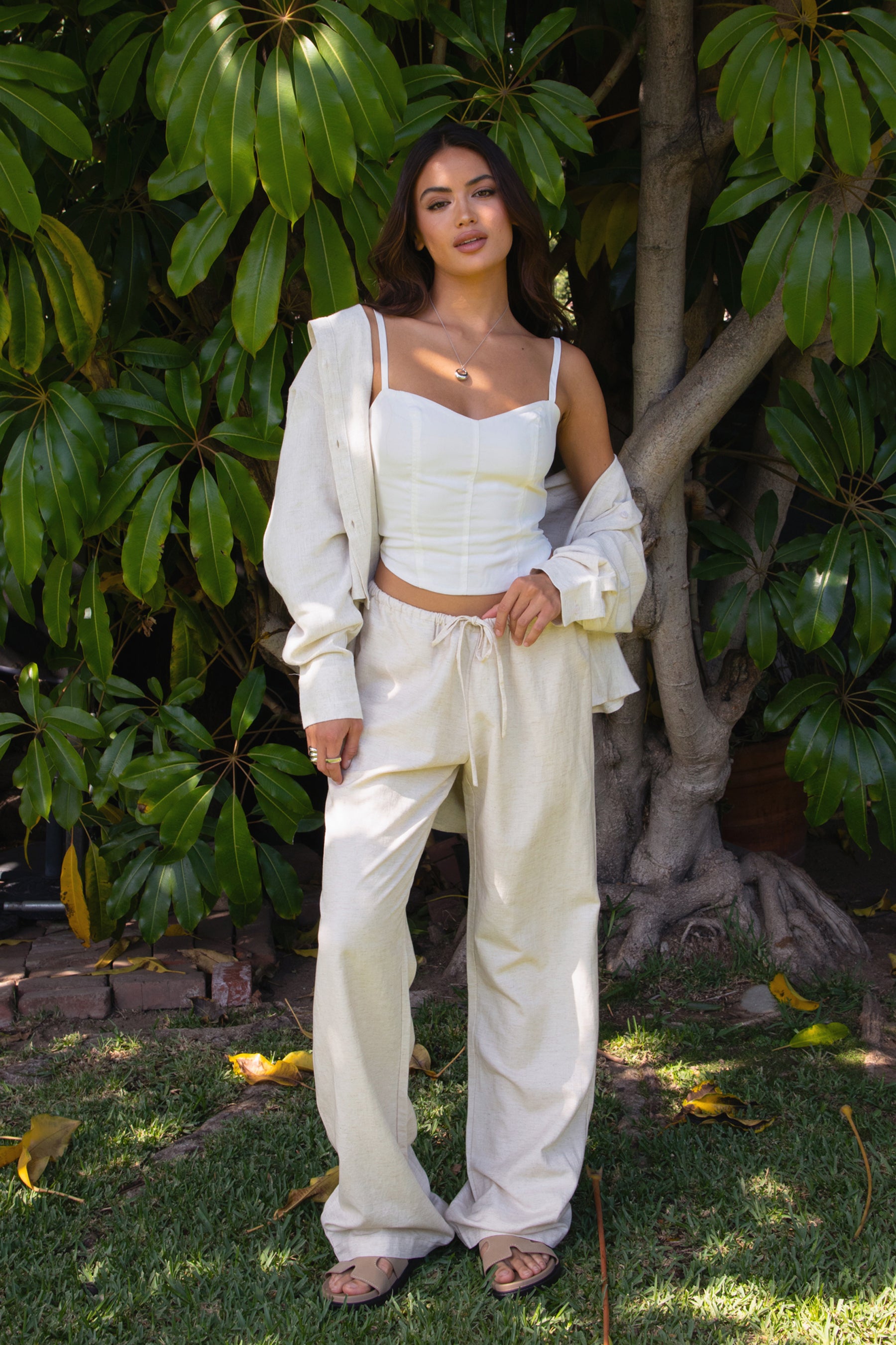 TH29606-SOPHEA Classic Natural Linen Cami Top is your go-to for effortless warm-weather style. Featuring a flattering V-neckline, adjustable spaghetti straps, and a smocked back for added comfort and stretch, this cami is finished with an asymmetrical curved hem for a soft, elevated touch. Made from a breathable linen blend perfect for lounging, summer travel, or a breezy boho-inspired look.

Pairs perfectly with matching pieces (sold separately: PA31289, TH29602).

50% VISCOSE, 35% LINEN, 15% POLYESTER, LI