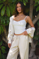 TH29606-SOPHEA Classic Natural Linen Cami Top is your go-to for effortless warm-weather style. Featuring a flattering V-neckline, adjustable spaghetti straps, and a smocked back for added comfort and stretch, this cami is finished with an asymmetrical curved hem for a soft, elevated touch. Made from a breathable linen blend perfect for lounging, summer travel, or a breezy boho-inspired look.

Pairs perfectly with matching pieces (sold separately: PA31289, TH29602).

50% VISCOSE, 35% LINEN, 15% POLYESTER, LI