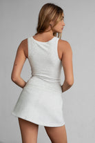Woman wearing TIC TOC SOMI Core Basic Rib Jersey Tank Top in heather white with low square neckline, wide straps, and form-fitting ribbed fabric, paired with a heather white mini skirt.