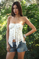 Woman wearing TIC TOC TH31655 APRICOT floral stripe sheer babydoll tank top featuring soft stretch lace fabric with delicate floral and stripe print, a ruched strapless bust, layered sheer design with light milk lining, and a ruffled handkerchief hem for a romantic western-inspired summer look.