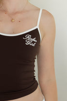 Woman wearing RODETTE soft stretch lettering crop tank top featuring contrast shoulder straps and neckline, brushed stretch nylon fabric, Rodeo Girl embroidered chest detail, adjustable thin straps, and a body-hugging cropped silhouette for western-inspired casual styling.