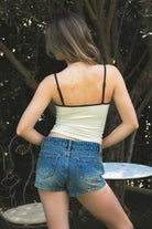 Woman wearing RODETTE soft stretch lettering crop tank top featuring contrast shoulder straps and neckline, brushed stretch nylon fabric, Rodeo Girl embroidered chest detail, adjustable thin straps, and a body-hugging cropped silhouette for western-inspired casual styling.
