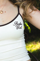 Woman wearing RODETTE soft stretch lettering crop tank top featuring contrast shoulder straps and neckline, brushed stretch nylon fabric, Rodeo Girl embroidered chest detail, adjustable thin straps, and a body-hugging cropped silhouette for western-inspired casual styling.