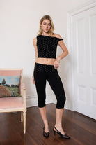 Woman wearing TIC TOC TH31776-JAIME-TP JAIME lightweight one shoulder polka dot top featuring a soft micro polka dot stretch fabric, asymmetrical off-the-shoulder neckline, twist strap detail, side ruching, and a slim hip-length silhouette for a chic day-to-night look.