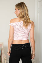 Woman wearing TIC TOC TH31776-JAIME-TP JAIME lightweight one shoulder polka dot top featuring a soft micro polka dot stretch fabric, asymmetrical off-the-shoulder neckline, twist strap detail, side ruching, and a slim hip-length silhouette for a chic day-to-night look.