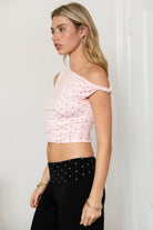 Woman wearing TIC TOC TH31776-JAIME-TP JAIME lightweight one shoulder polka dot top featuring a soft micro polka dot stretch fabric, asymmetrical off-the-shoulder neckline, twist strap detail, side ruching, and a slim hip-length silhouette for a chic day-to-night look.