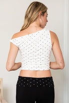 Woman wearing TIC TOC TH31776-JAIME-TP JAIME lightweight one shoulder polka dot top featuring a soft micro polka dot stretch fabric, asymmetrical off-the-shoulder neckline, twist strap detail, side ruching, and a slim hip-length silhouette for a chic day-to-night look.