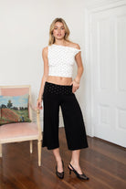 Woman wearing TIC TOC TH31776-JAIME-TP JAIME lightweight one shoulder polka dot top featuring a soft micro polka dot stretch fabric, asymmetrical off-the-shoulder neckline, twist strap detail, side ruching, and a slim hip-length silhouette for a chic day-to-night look.