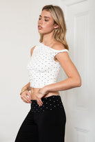 Woman wearing TIC TOC TH31776-JAIME-TP JAIME lightweight one shoulder polka dot top featuring a soft micro polka dot stretch fabric, asymmetrical off-the-shoulder neckline, twist strap detail, side ruching, and a slim hip-length silhouette for a chic day-to-night look.