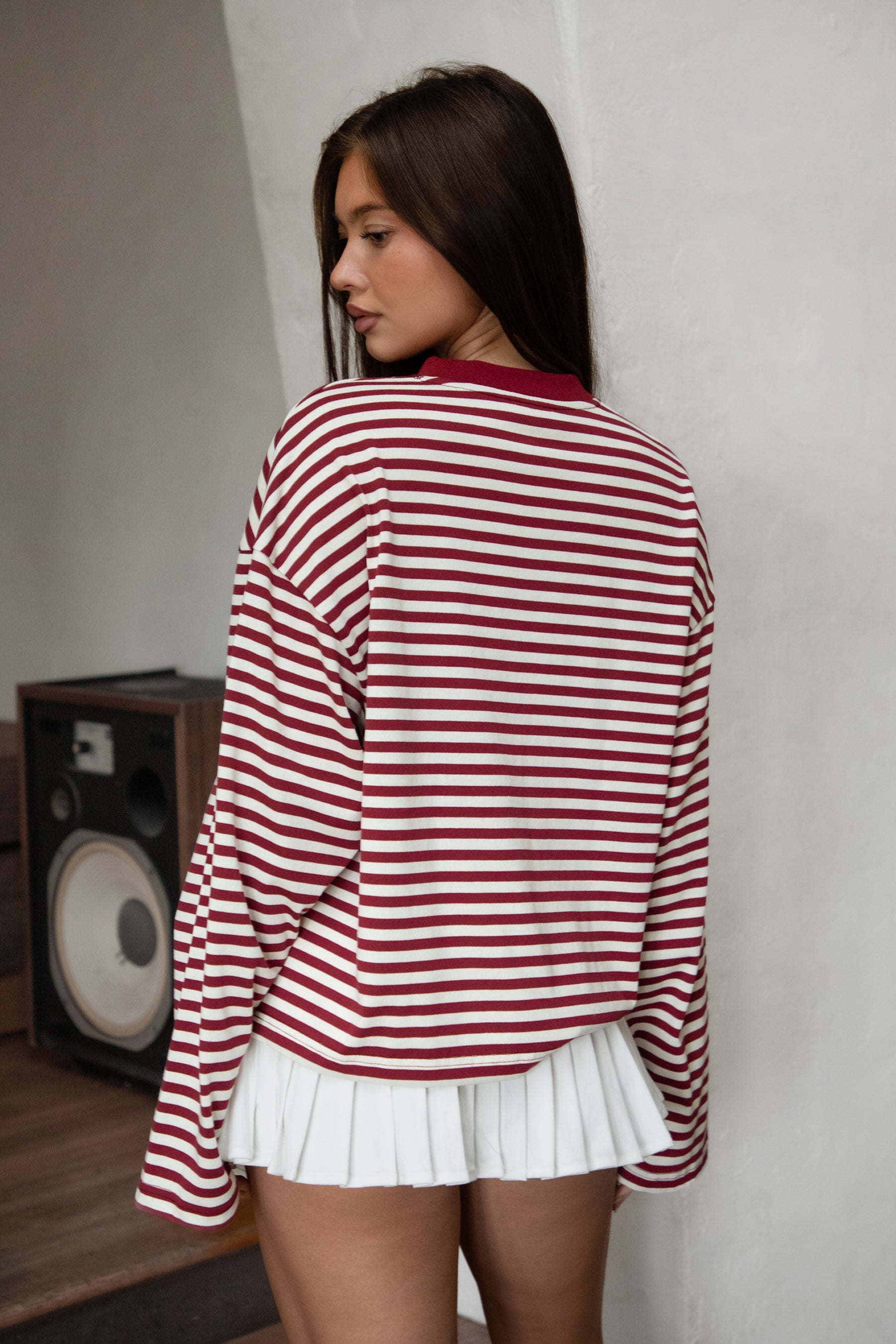 Woman wearing TIC TOC TH31849 MARLOWE striped long sleeve top with a classic crew neckline, relaxed semi-oversized fit, easy drop shoulders, and soft horizontal stripes paired with dark denim jeans in a casual outdoor street setting.
