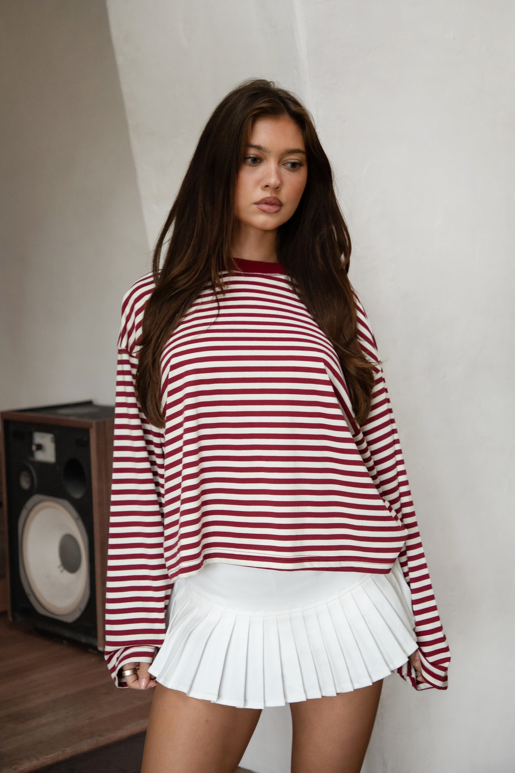 Woman wearing TIC TOC TH31849 MARLOWE striped long sleeve top with a classic crew neckline, relaxed semi-oversized fit, easy drop shoulders, and soft horizontal stripes paired with dark denim jeans in a casual outdoor street setting.