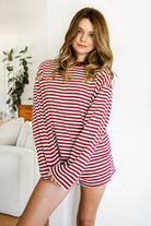 Woman wearing TIC TOC TH31849 MARLOWE striped long sleeve top with a classic crew neckline, relaxed semi-oversized fit, easy drop shoulders, and soft horizontal stripes paired with dark denim jeans in a casual outdoor street setting.