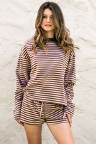 Woman wearing TIC TOC TH31849 MARLOWE striped long sleeve top with a classic crew neckline, relaxed semi-oversized fit, easy drop shoulders, and soft horizontal stripes paired with dark denim jeans in a casual outdoor street setting.