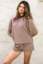 Woman wearing TIC TOC TH31849 MARLOWE striped long sleeve top with a classic crew neckline, relaxed semi-oversized fit, easy drop shoulders, and soft horizontal stripes paired with dark denim jeans in a casual outdoor street setting.