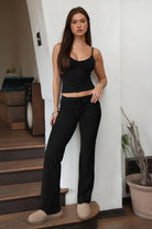 Woman wearing TIC TOC TH31906BA-NYLEE-CAM NYLEE Soft Span Jersey Cami Top in a dark neutral tone, featuring a delicate V-neckline with slim cami straps, clean minimal seaming, cropped second-skin silhouette, and smooth stretch fit, styled with coordinating NYLEE bottoms for a matching lounge/athleisure set.