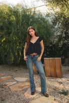 Woman wearing TIC TOC TH31912-AVELINE AVELINE V-neck boho lace trim babydoll top featuring a deep V-neckline with lace trim, mini puff sleeves with soft elastic cuffs, front button detail at the bodice, tiered babydoll silhouette with ruffle hem, and a smocked fitted back with adjustable bow tie in lightweight cotton voile, styled with denim for a soft boho western romantic everyday look