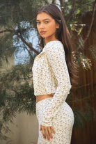 Woman wearing TIC TOC TH31983-LYNN-LC LYNN floral pointelle print long sleeve cardigan featuring a round neckline with button front, six-button closure, long sleeves with ribbed cuffs, cropped cardigan length, and soft airy stretch ribbed floral pointelle fabric, styled over a matching floral pointelle cami and lounge pants for a coordinated feminine lounge set.