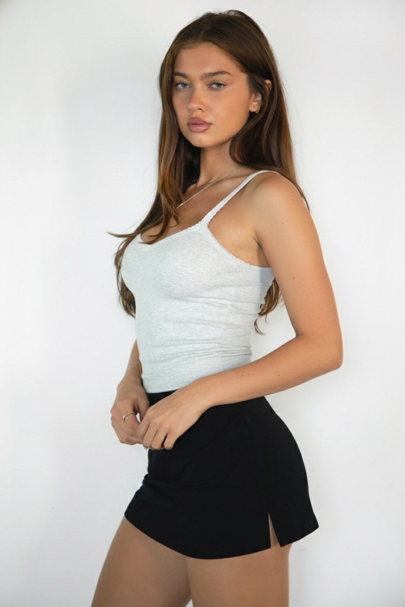 Woman wearing TIC TOC TH32025BA-ROMIE ROMIE V-neck spaghetti strap tank top featuring a delicate picot trim neckline, slim body hugging rib jersey fabric, and adjustable straps, styled with casual bottoms for an easy everyday lounge-and-layering look.