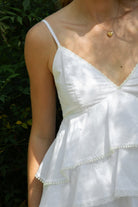 Woman wearing TIC TOC TH32062 GLARA tiered ruffle babydoll top featuring a plunging V-neckline with lace trim, tiered ruffle layers with lace edge detail, adjustable thin spaghetti straps, and a soft flowy babydoll silhouette in lightweight cotton poplin for a feminine western summer look.