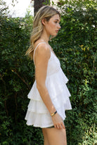 Woman wearing TIC TOC TH32062 GLARA tiered ruffle babydoll top featuring a plunging V-neckline with lace trim, tiered ruffle layers with lace edge detail, adjustable thin spaghetti straps, and a soft flowy babydoll silhouette in lightweight cotton poplin for a feminine western summer look.