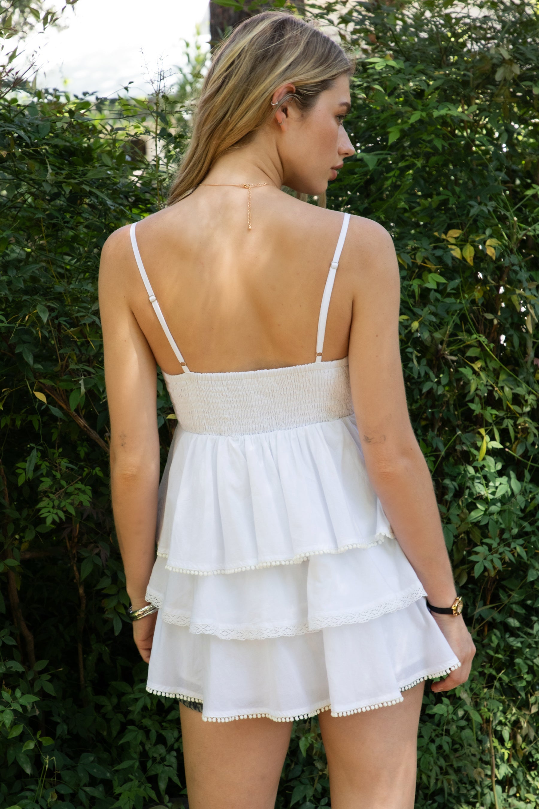 Woman wearing TIC TOC TH32062 GLARA tiered ruffle babydoll top featuring a plunging V-neckline with lace trim, tiered ruffle layers with lace edge detail, adjustable thin spaghetti straps, and a soft flowy babydoll silhouette in lightweight cotton poplin for a feminine western summer look.