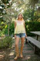 Woman wearing ROSA V-neck lace trim sheer babydoll cami top featuring a scalloped lace neckline, adjustable spaghetti straps with Y-back design, sheer crinkle rayon fabric with airy drape, floral lace panels at the bust and back, and a flowy silhouette with lace trim hem.