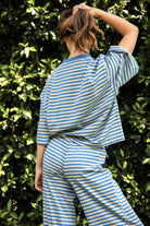 Woman wearing MARLOWE classic crewneck striped short sleeve top featuring a soft horizontal stripe pattern, relaxed semi oversized fit, drop shoulder short sleeves, lightweight stretch cotton blend, and clean straight hemline for casual lounge and coastal styling.